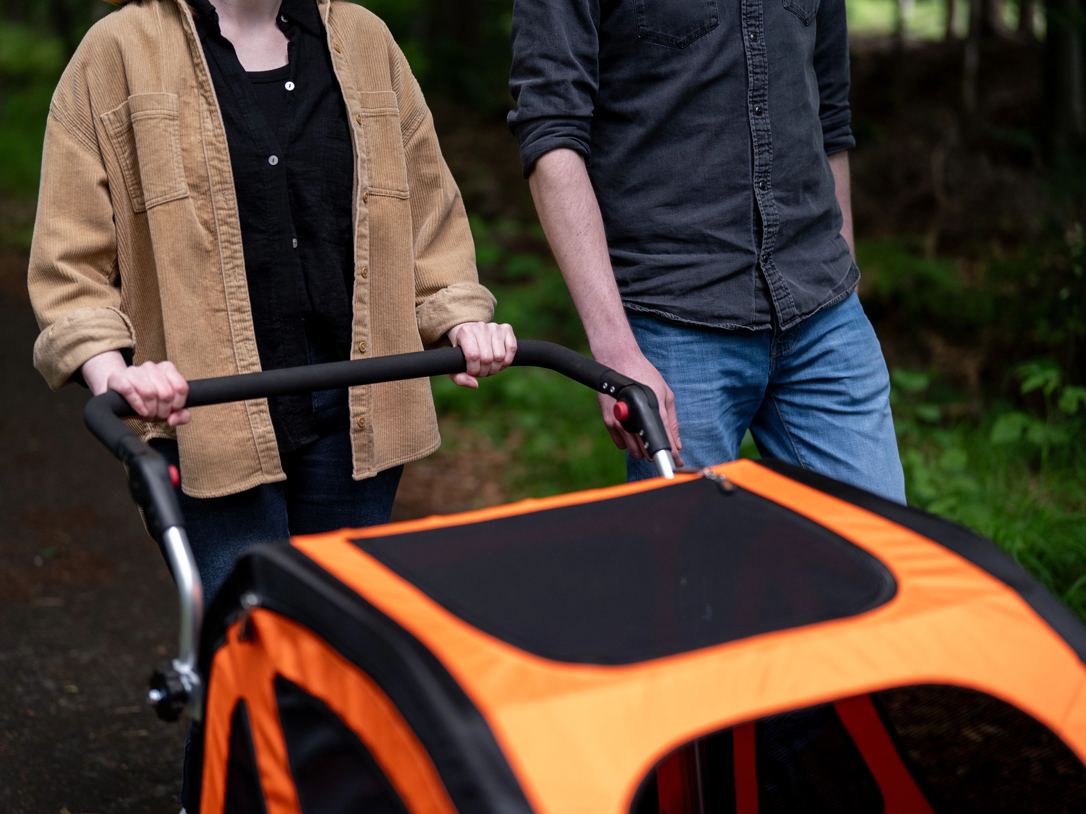 eine Frau schiebt den DogBus mithilfe des angebauten Stroller Kits